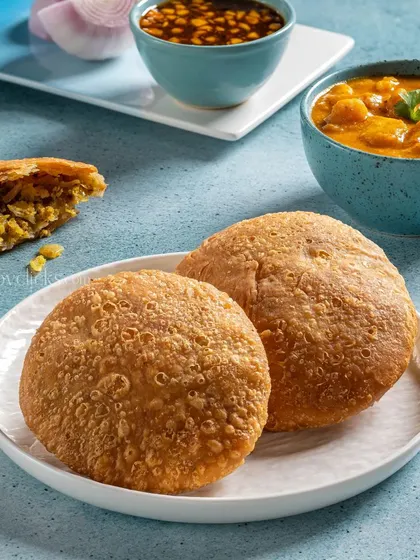Crispy Kachoris served with a side of spicy potato curry, a popular breakfast and snack item.