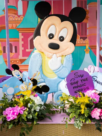 A cute baby Mickey prop surrounded by flowers, part of the detailed decor that brings the Disney theme to life.