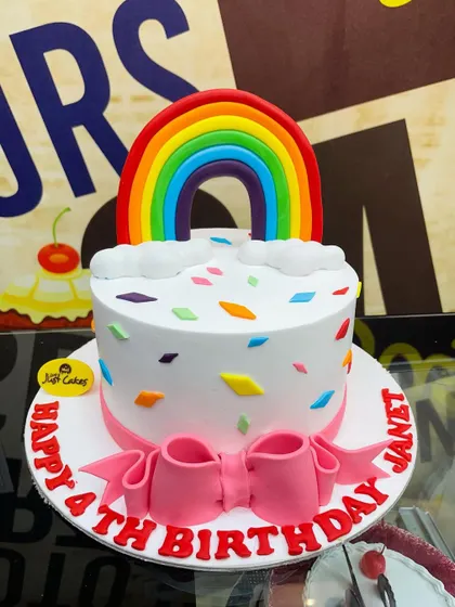 A 2kg rainbow-themed cake with a big fondant bow and colorful confetti sprinkles.
