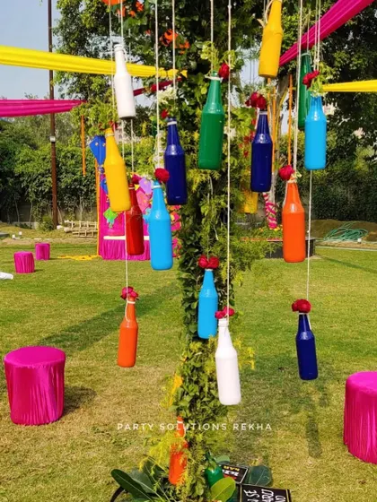 A creative and modern twist on outdoor decor. I used colorful painted bottles as hanging decorations, adding a pop of unexpected color and a touch of whimsy to this Mehendi function.