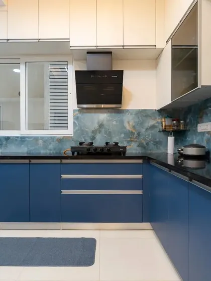 This angle of the blue kitchen highlights the under-cabinet lighting and the window that brings in natural light, making the space feel bright and functional.