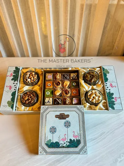 This expansive gift box is designed to impress, featuring a beautiful flamingo motif. It opens to reveal four jars of assorted dry fruits and a central compartment filled with our signature baklava and other sweets.