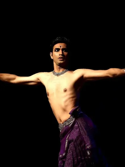 A dynamic pose from a live performance, showcasing the physical control and energy required for a full-length solo recital.
