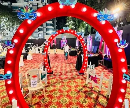 The entrance to the Carnival party was designed as a tunnel of illuminated arches decorated with masks, immediately immersing guests in the theme.