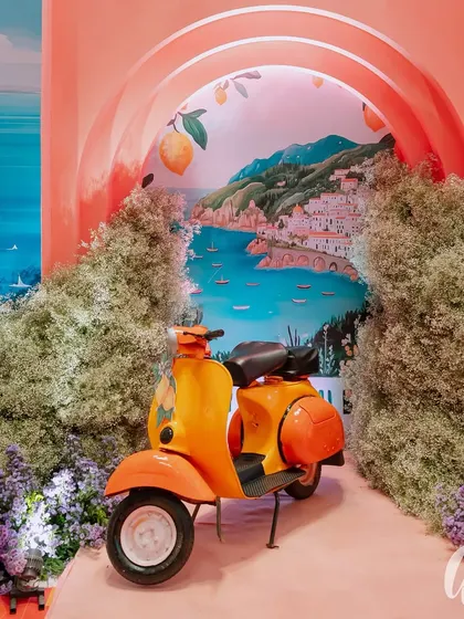 We created a perfect photo opportunity with a vintage orange Vespa set against a custom-painted backdrop of the Amalfi Coast. This immersive installation became a favorite spot for guests to capture memories.