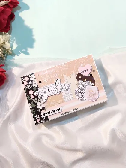 A mini scrapbook with a sophisticated black, white, and floral theme for an anniversary.