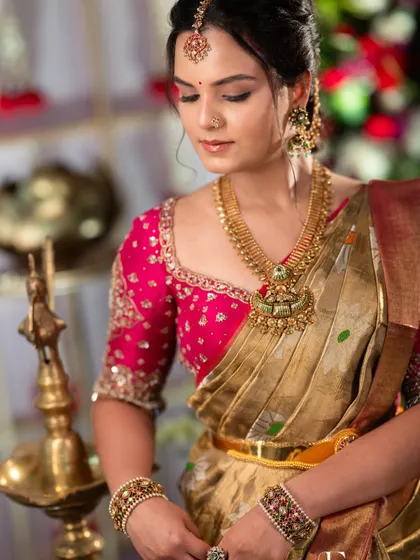 A close-up on the details. The makeup highlights her eyes, and the skin has a beautiful, natural glow that pairs perfectly with the traditional gold jewellery.