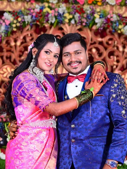 A classic posed photo of the couple at their wedding reception, smiling for the camera.