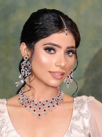 An elegant look for a pre-wedding function. The makeup is soft and luminous, with a touch of shimmer on the eyes, paired with beautiful ruby and diamond jewelry.