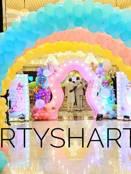 A multi-layered rainbow balloon arch creates a stunning and colorful entrance for a Candyland or rainbow-themed party.