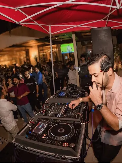 On the mic and on the decks at an outdoor gig at Kiki Pune. It's a constant balance of technical skill and crowd engagement.