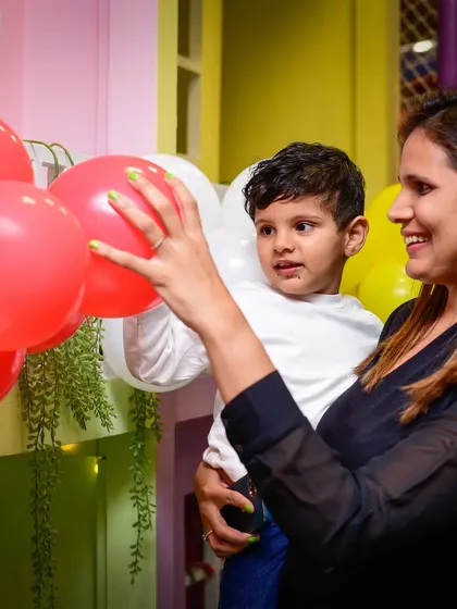 The joy of little things, like playing with a bright red balloon. A mother and her child share a sweet moment together.