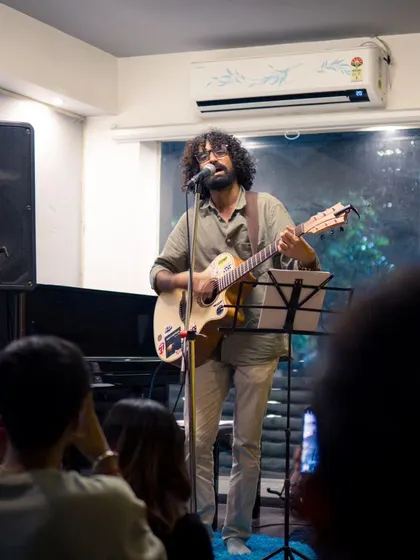 A wide shot of an artist commanding the stage during a live gig. You can see our full setup with speakers, a piano, and a dedicated space for the audience to enjoy the show.