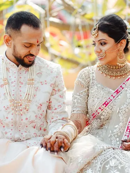 Jeenal and Chirantan holding hands on a bench. The focus on their intertwined hands and the gentle look they share creates a simple yet powerful image of their bond.
