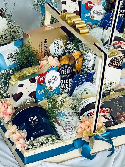 A side view of a luxury snack hamper, highlighting the beautiful floral arrangement and the layers of delicious goodies inside.