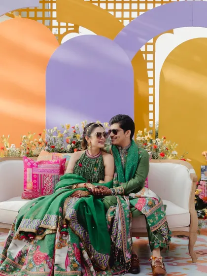 The couple's seating at their Ooty haldi was a vibe. A simple sofa set against a backdrop of colorful arches and florals for that perfect photo op.