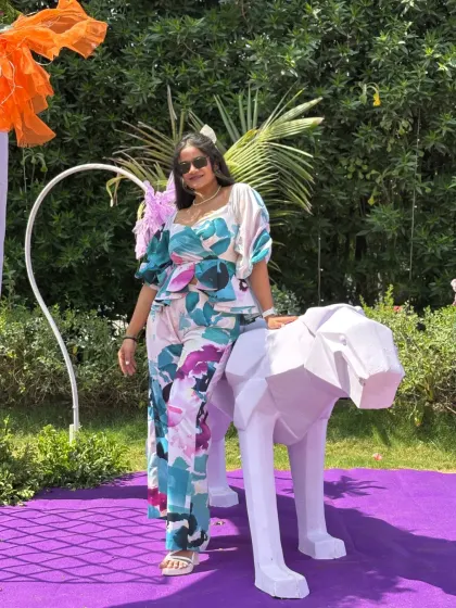 Posing next to a geometric animal statue, one of the many unique decor elements at the wedding carnival.