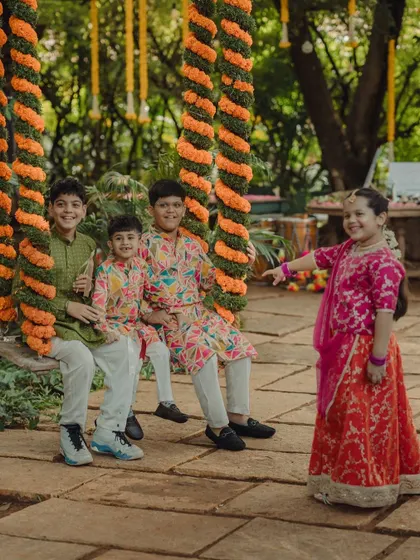 Children playing on the marigold-decorated swing, showing how our decor creates fun for everyone.