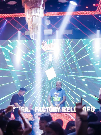 A wide shot of me commanding the stage and the massive LED screen at Sugar Factory.