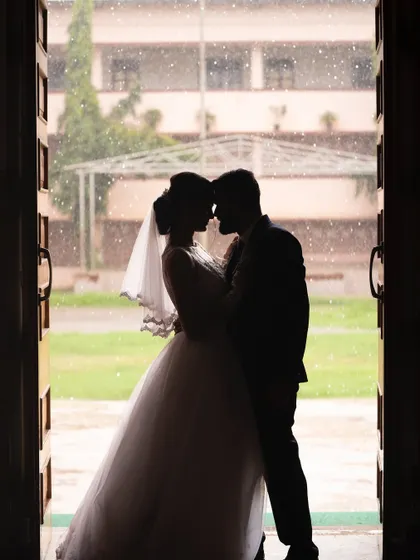 A stunning silhouette of a bride and groom in a doorway. This artistic shot uses light and shadow to create a powerful and romantic image that feels timeless.