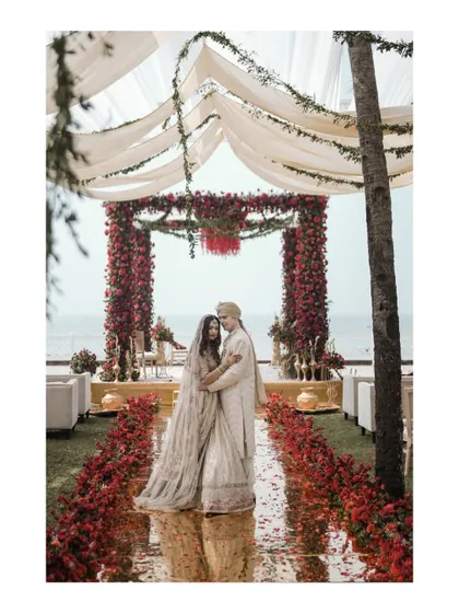 The couple stands under their beautiful mandap by the sea at the Taj Holiday Village, Goa.