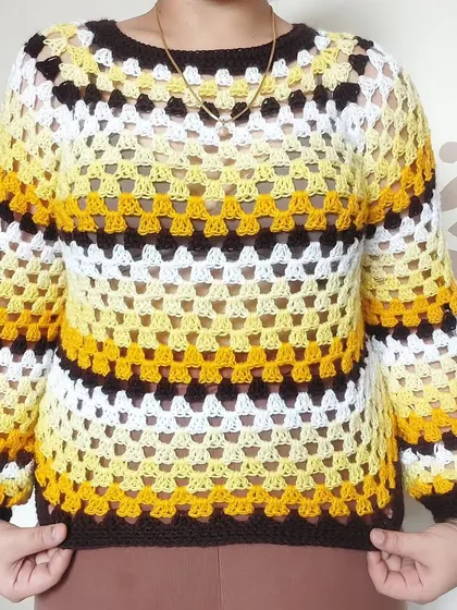 A classic granny stitch sweater is a cozy wardrobe essential. I created this piece with a vibrant, striped color scheme and balloon sleeves, but I can customize the colors and fit to match your personal style perfectly.