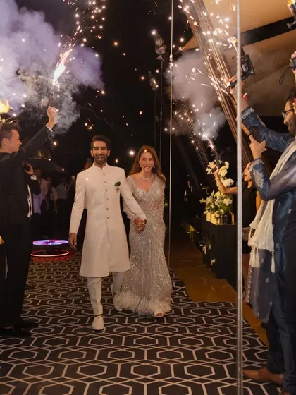 Couple entries should be grand and energetic. For this Sangeet, I planned a sparkling entrance with guests holding cold-pyro guns, creating a tunnel of light for the couple to walk through.