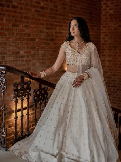 A vision in white. This engagement lehenga is perfectly complemented by a soft, subtle makeup look that focuses on a flawless, dewy complexion.