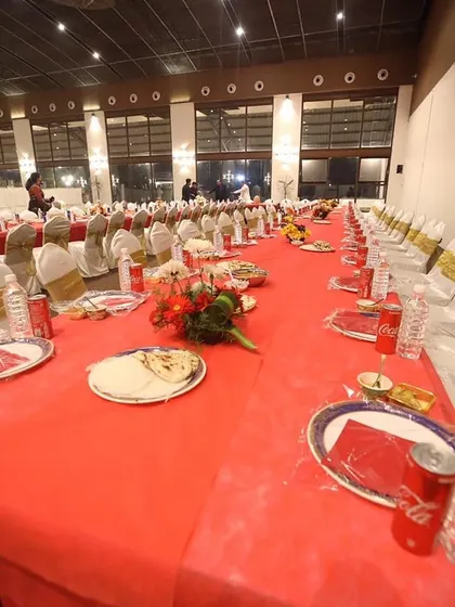 A closer look at the long table setup at Anantia Palace Ground. Every detail is arranged before guests arrive, from the plates and drinks to the fresh naan bread.