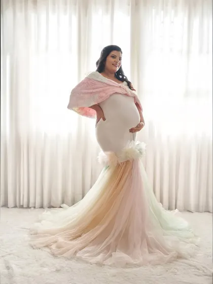 A full-length view of the rainbow pastel gown. The mermaid-style fit is made of comfortable stretch fabric, while the tulle trail adds a splash of color and fun.