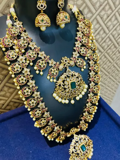 A beautiful uncut stone (Kundan) set with a floral design, studded with Kempu and green stones.