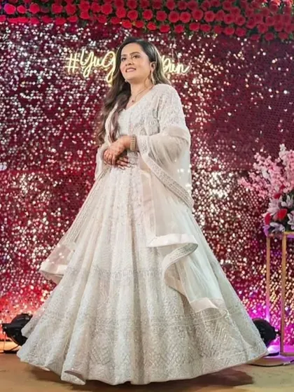 A stunning sangeet look for this bride. The soft waves in her hair and the glowing makeup are perfect against the glittering backdrop.