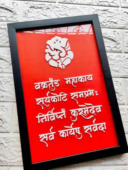 This Ganesha wall frame looks stunning against a textured brick wall, adding a spiritual and artistic element.