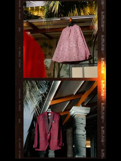 A creative shot of the bride and groom's reception outfits hanging.