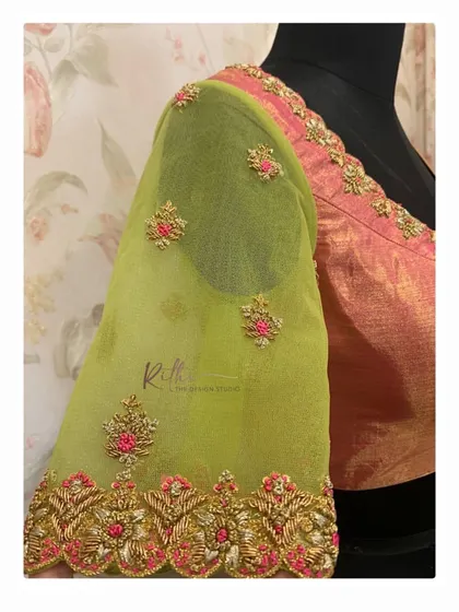 A side view of the pink and green blouse, highlighting the delicate floral embroidery on the sheer net sleeve.