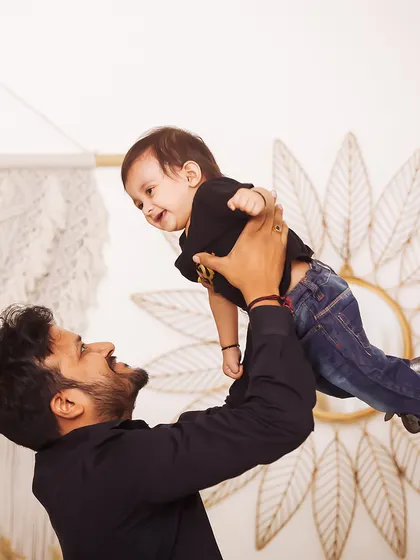 A father's joy as he lifts his child into the air. This dynamic and happy studio shot is full of energy and love.