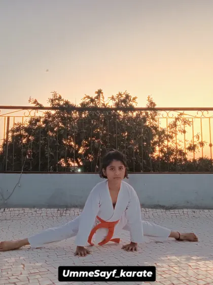 Flexibility is a cornerstone of karate, and we build it with consistent stretching and conditioning. This student demonstrates incredible dedication, mastering a full split against the backdrop of the evening sky. Practice makes you perfect.