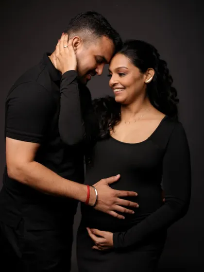 A classic, romantic pose, with the couple sharing a quiet, loving moment in the studio.