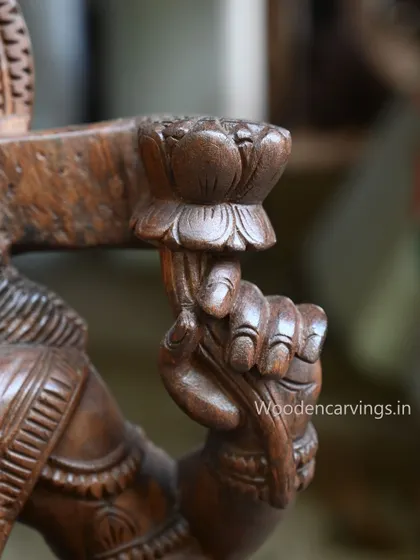 A close-up of one of the hands of the 36-inch MahaLakshmi holding a lotus bud.