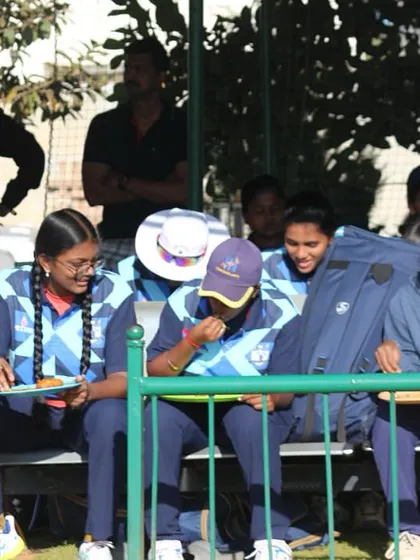 Players from the women's team relax in the dugout during a break in play.