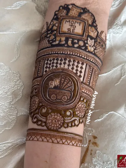 The arm band in progress, with the baby in the pram motif added below the "Mom to be" frame.
