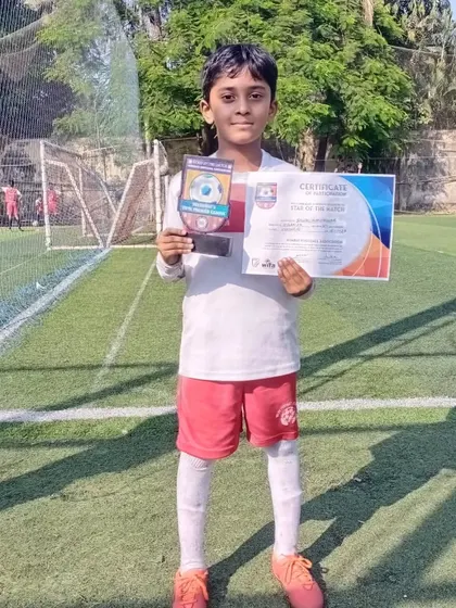 A young player proudly displays his "Star of the Match" certificate and trophy. We celebrate these individual moments of brilliance as they build the foundation for future success.