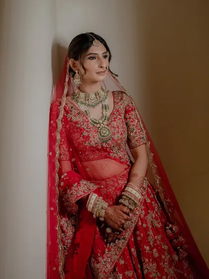 An artistic shot of the bride Yashvi. The lighting beautifully highlights the contours and the smooth, flawless finish of her wedding day makeup.