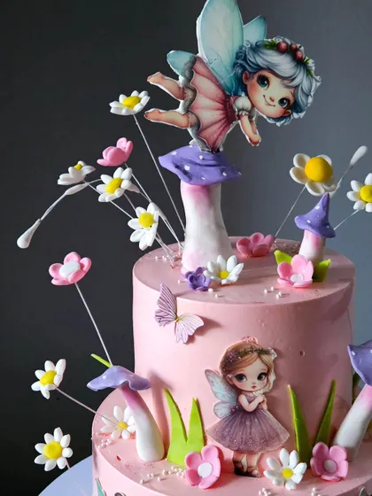 Another close-up of the fairy cake, focusing on the top tier's details, including the delicate wings of the fairy and the tiny flowers.