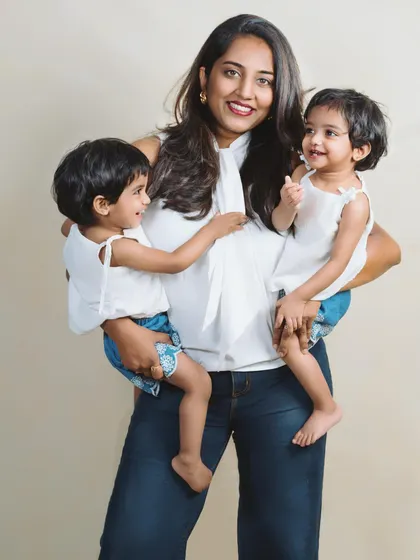 A mother's arms full of love, holding her twin daughters. This photo beautifully captures the joy and energy of life with two little ones.