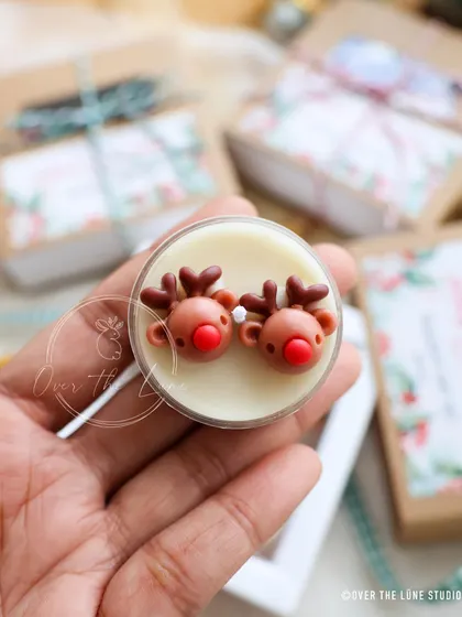 A close-up of the adorable reindeer couple tealight. Their little red noses are hand-painted.