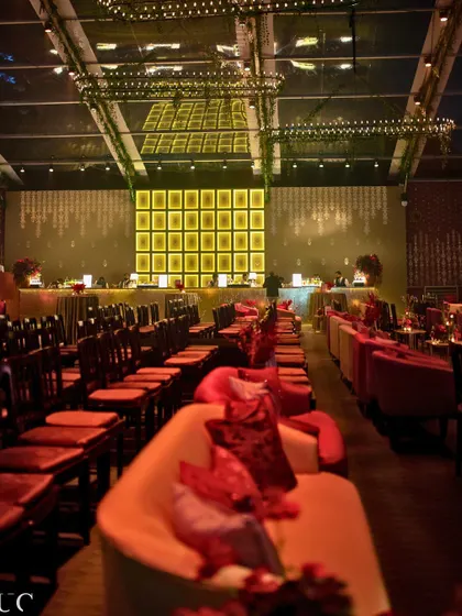 The Sangeet dinner area, with a stunning mirror ceiling installation reflecting the light and decor, and incorporating the groom's grandmother's cherished bonsai collection.