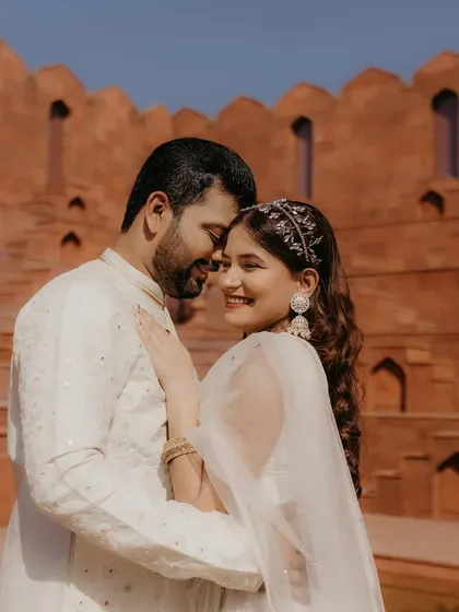 A happy and intimate moment from a pre-wedding photoshoot. The bride's natural, glowing makeup ensures she looks radiant and feels like herself, letting her joy shine through.