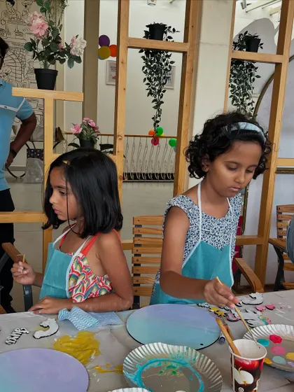 Two girls working side-by-side on their paintings. My parties are a great way for friends to bond over a shared creative activity.