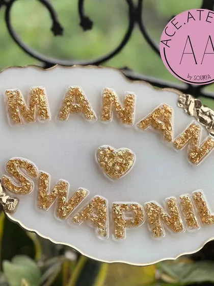 A beautiful white and gold nameplate for 'Manan & Swapnil'. The design is clean and modern, perfect for a contemporary home.